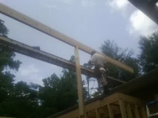 Carpenter setting a ridge beam over a new addition frame — Ice Dam Removal by Roofing Brothers in Putnam Valley