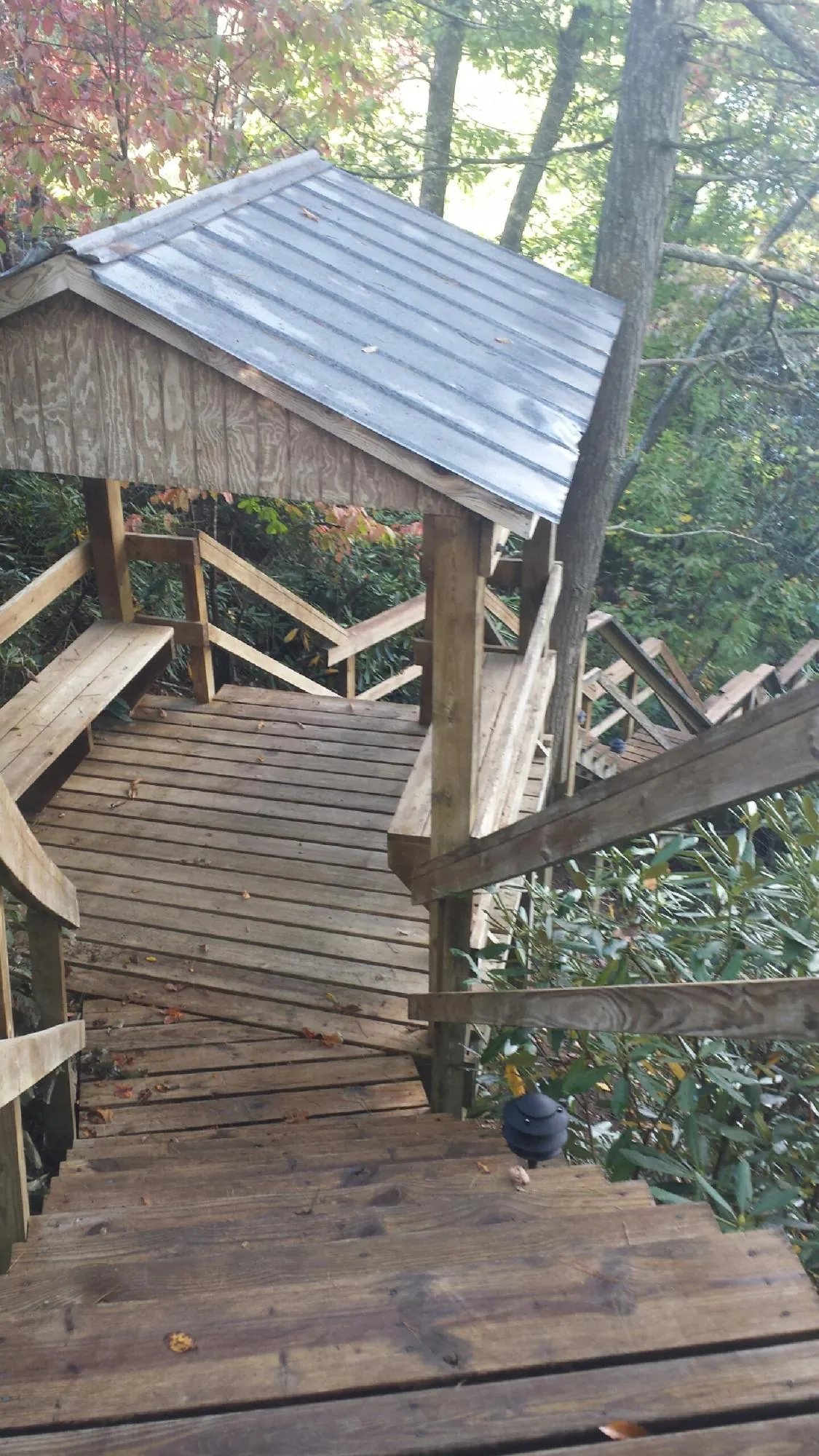 Metal roofed shelter over wooden steps on a wooded walkway — Skylight Repair & Installation work by our crew in Putnam Valley