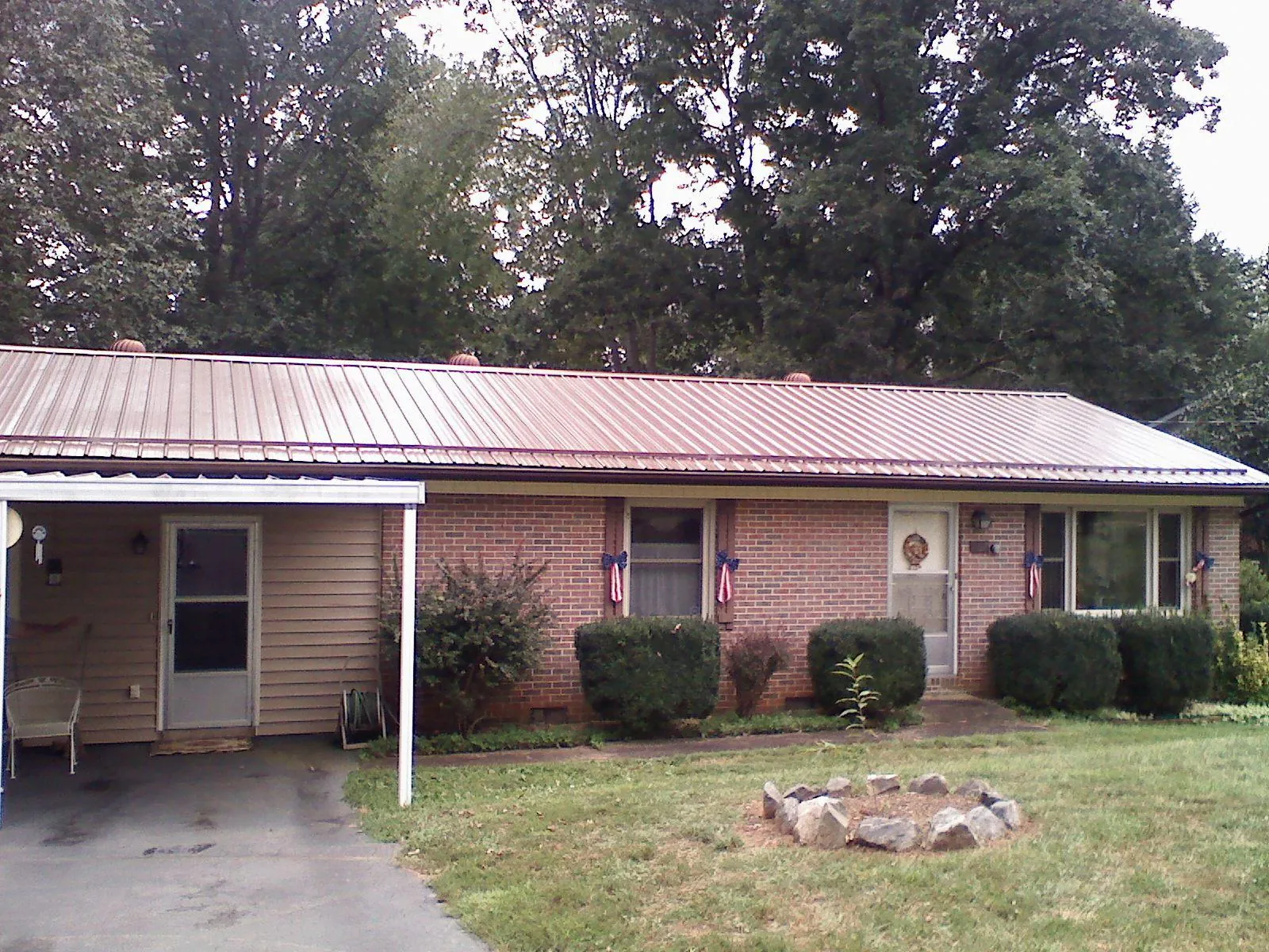 Bronze metal roof and carport on a brick ranch home — Roof Repair work by our crew in Putnam Valley